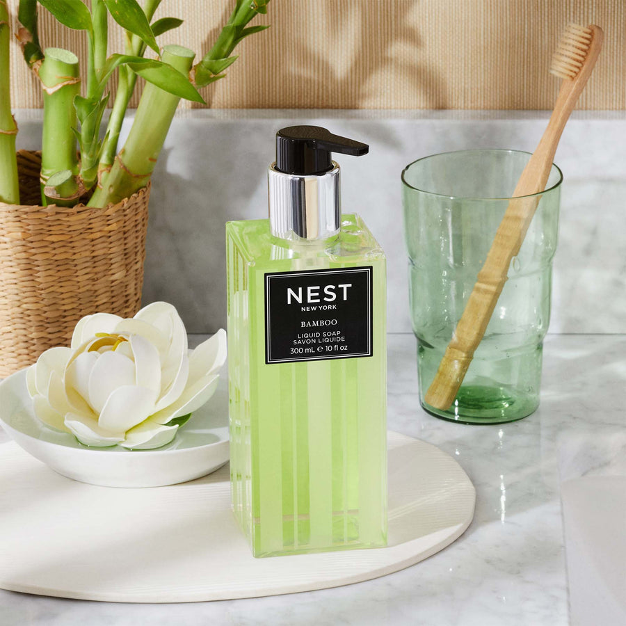 Bamboo Liquid Soap by NEST New York with bamboo, wicker basket, flower, and toothbrush