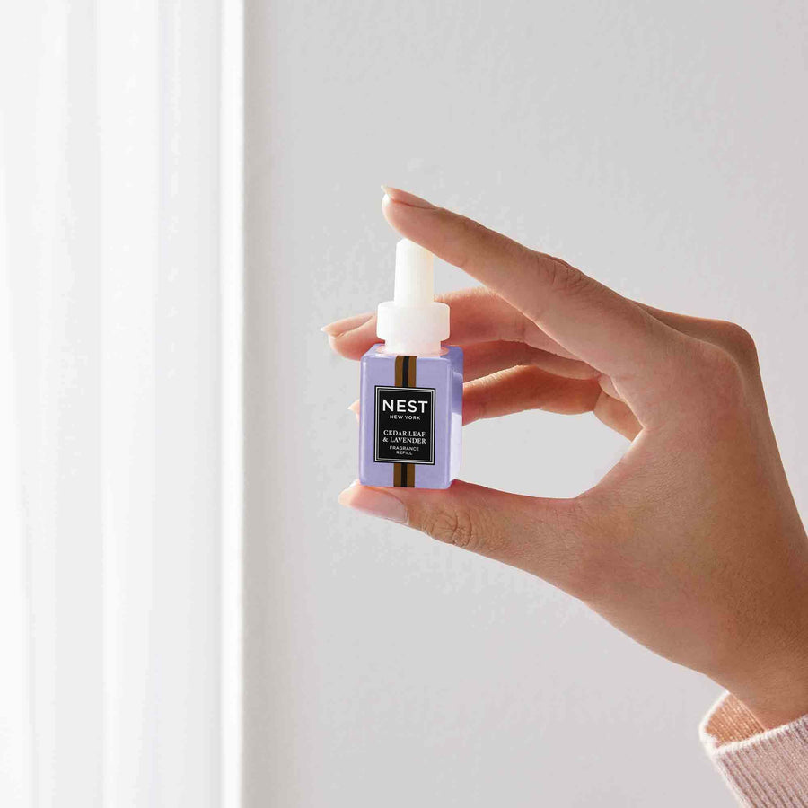 Cedar Leaf & Lavender Pura Refill by NEST New York with hand model
