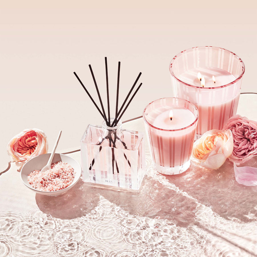 Himalayan Salt & Rosewater 3-Wick Candle, Classic Candle, and Reed Diffuser by NEST New York with flowers and Himalayan salt